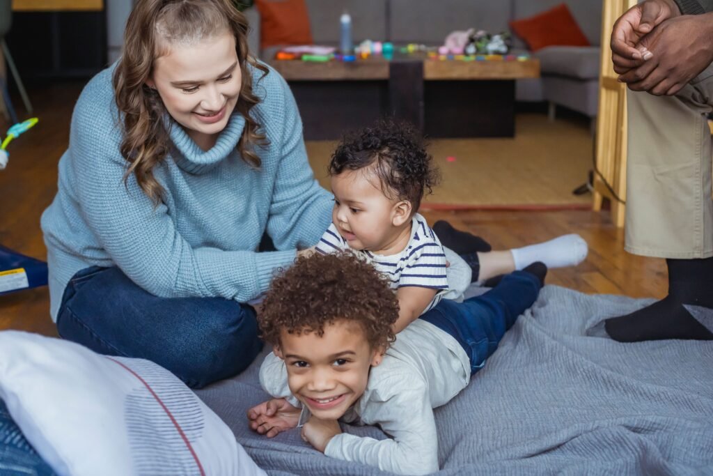 Cheerful diverse family having fun together while lying on blanket on floor during weekend